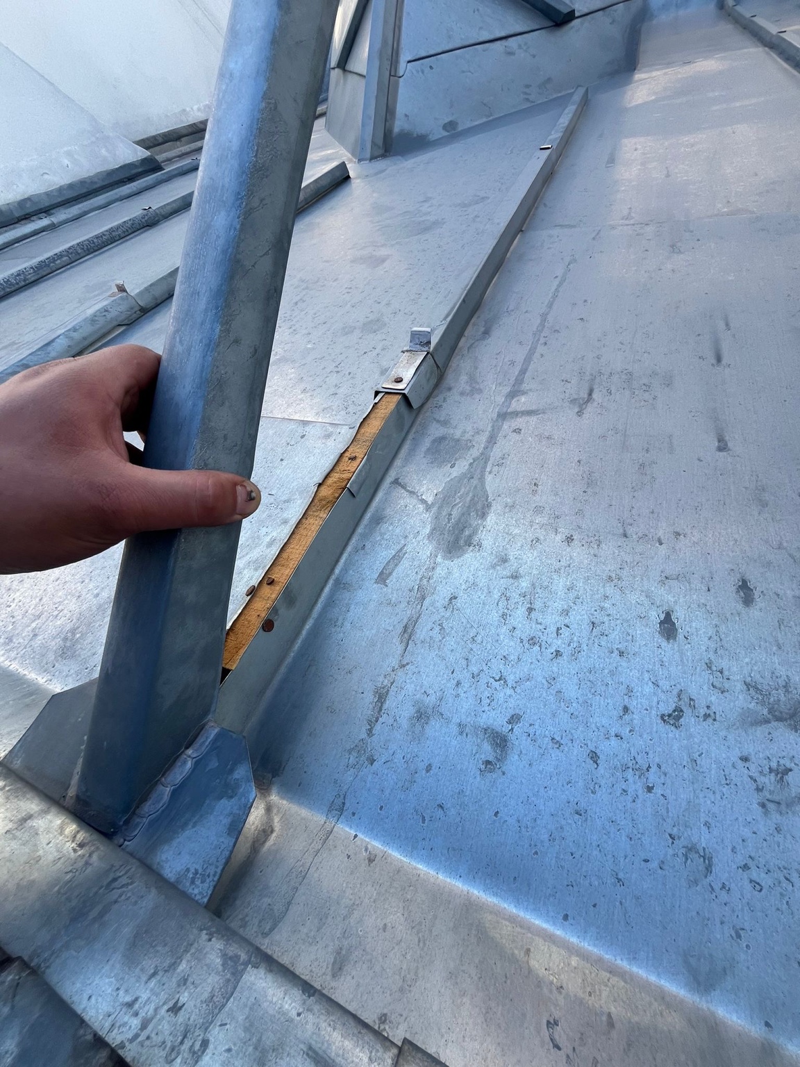 Relevé d’un couvre-joint lors d’une recherche de fuite sur couverture zinc